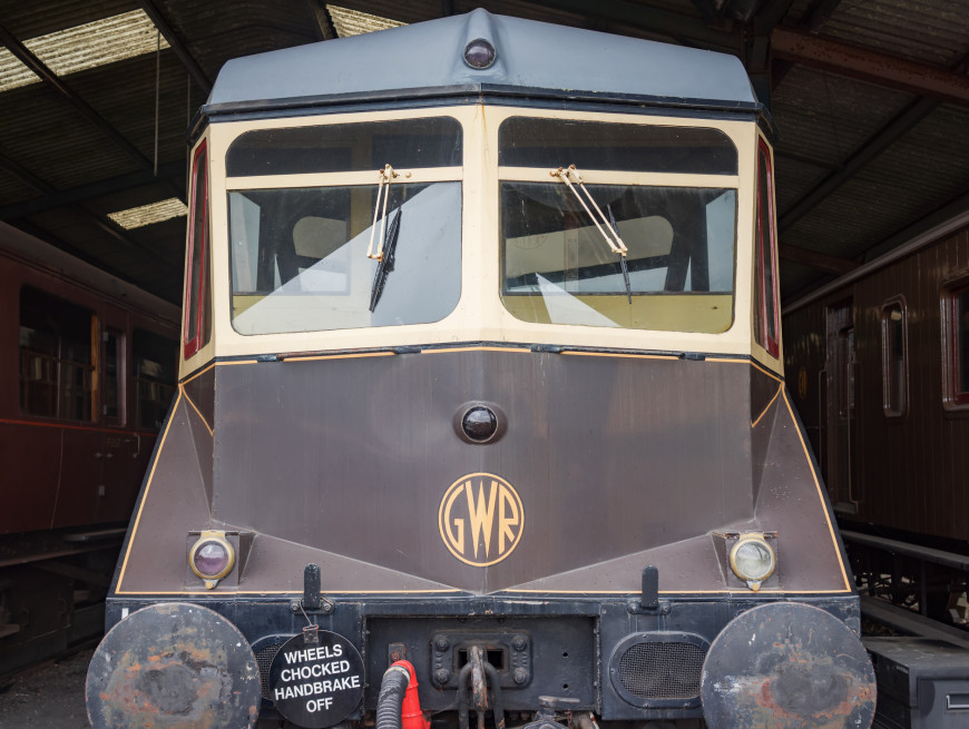 Front view of a vintage GWR train in a shed, with a